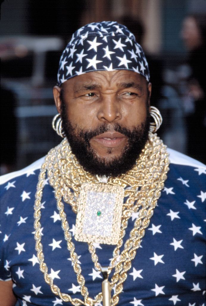 G. T nosi modro-belo zvezdasto bandano in zlate verižice z zlatimi obročki, ikono mode 80-ih