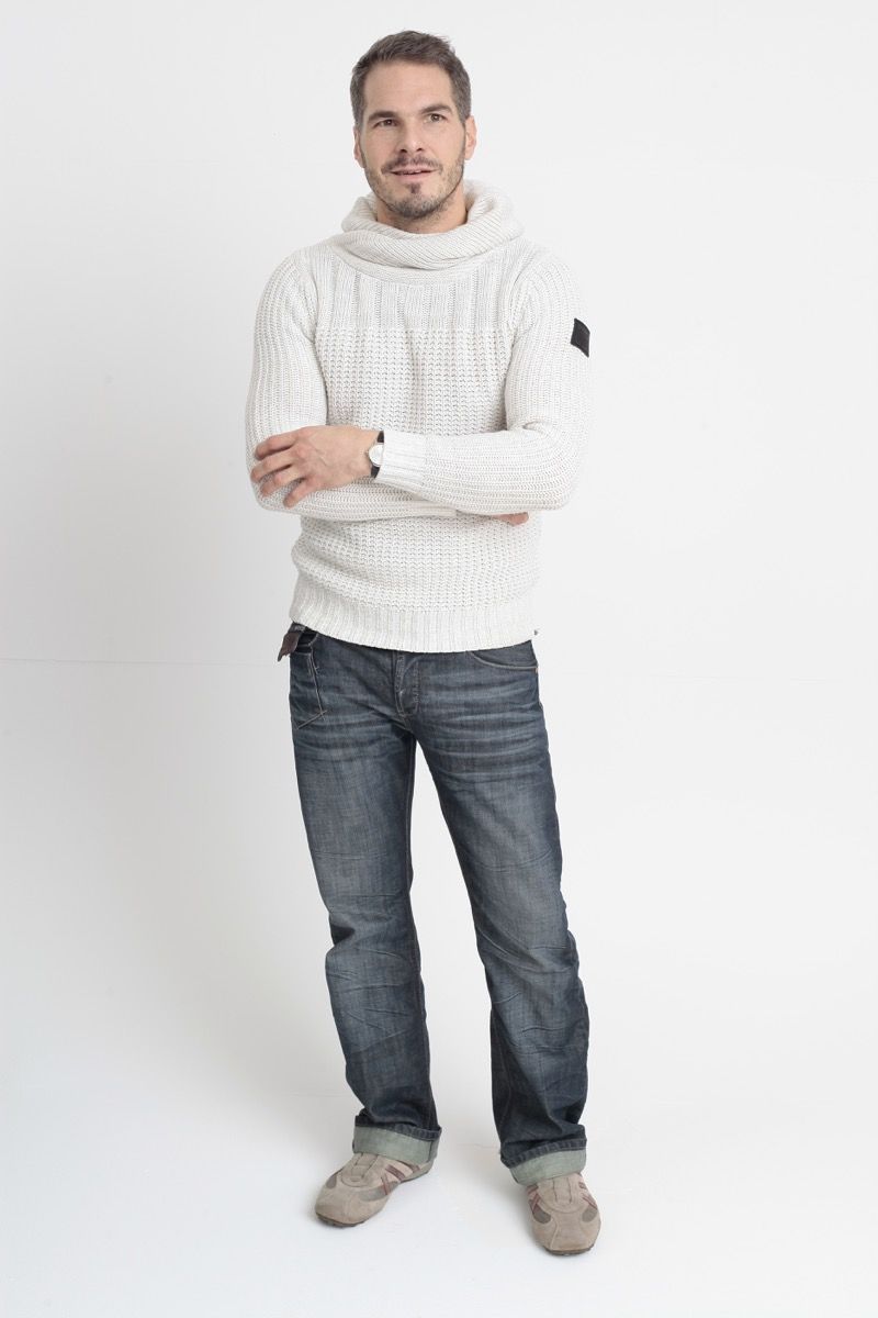 अपने 40 के दशक के फटे हुए जींस और सफेद स्वेटर पहने हुए आदमी