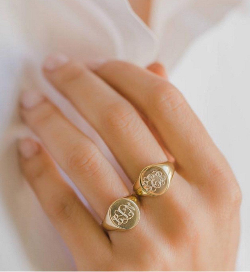 бяла ръка, носеща златен пръстен с цигет