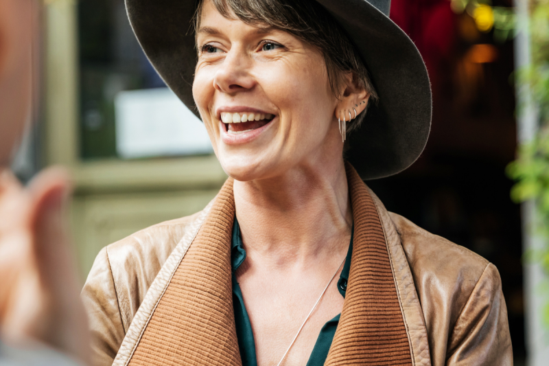   mujer riendo con sombrero de chaqueta de cuero