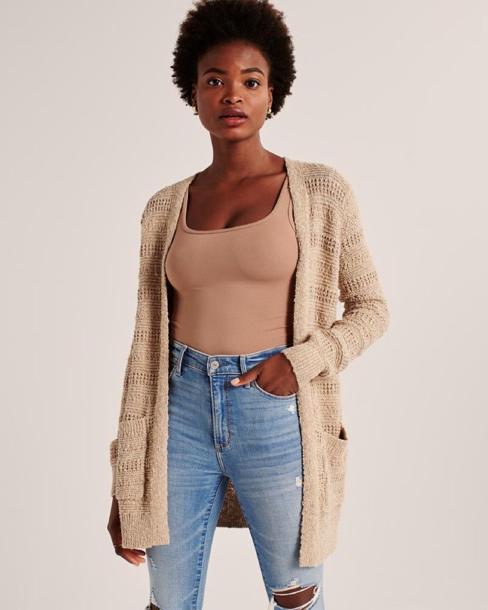 млада црнка у отвореном џемперу боје деве