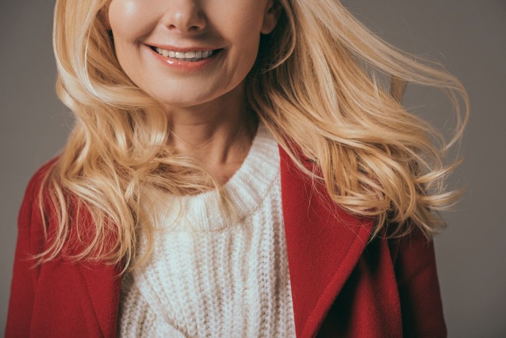 жена, облечена в бял пуловер и червен блейзър - как да се облечете над 50