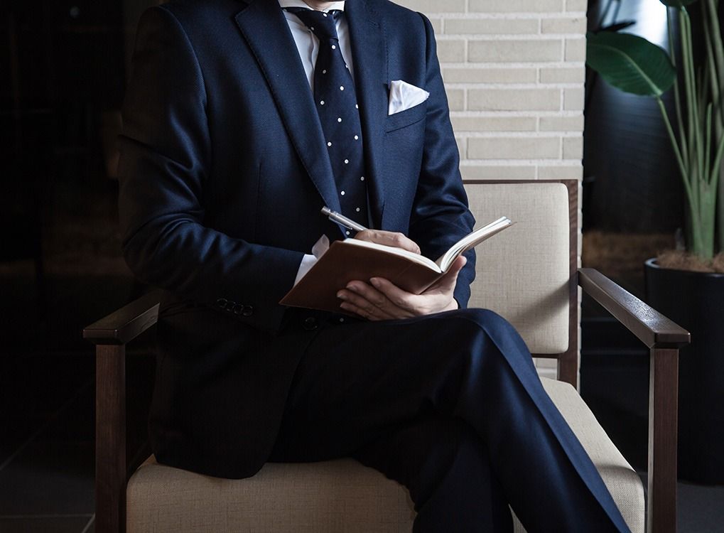 vyras su kostiumu ir skaito knygą - kaip apsirengti virš 50 metų