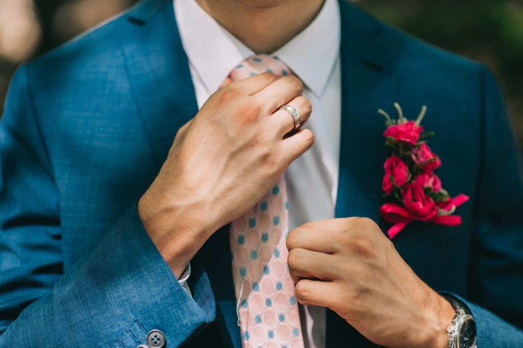 hombre sosteniendo su corbata y un traje - cómo vestirse más de 50