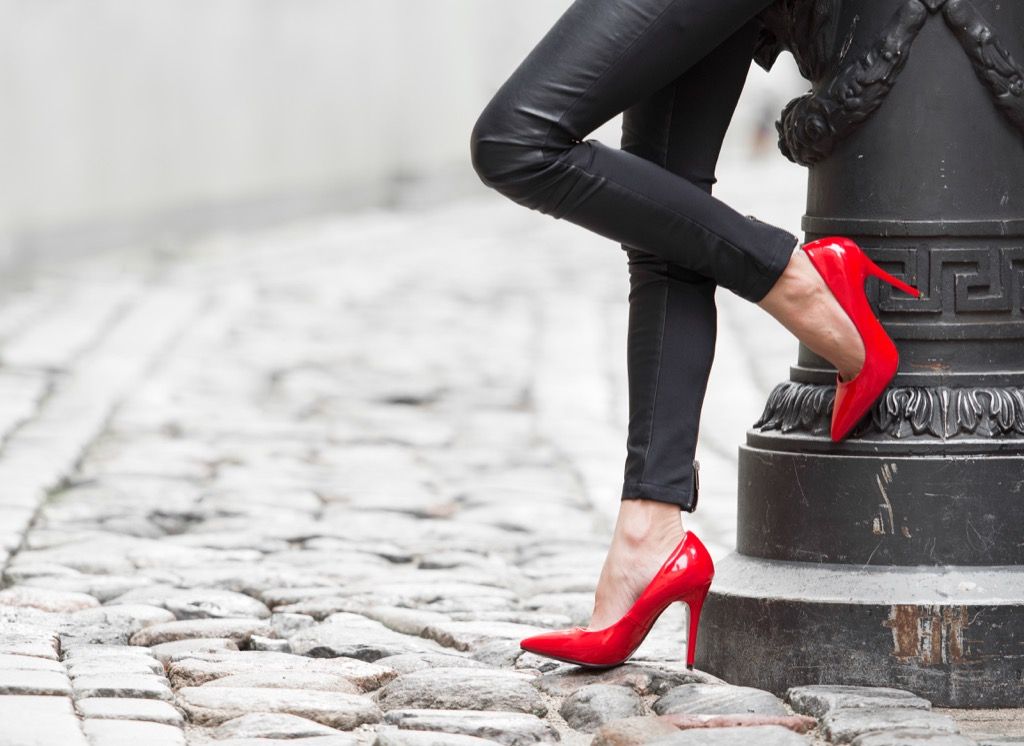 sieviete sarkanās kurpēs, atspiedusies pret luktura stabu - kā ģērbties virs 50