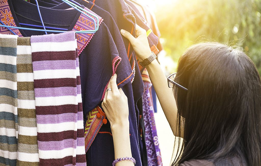 moteris žiūri į drabužių lentyną lauke - kaip apsirengti virš 50 metų