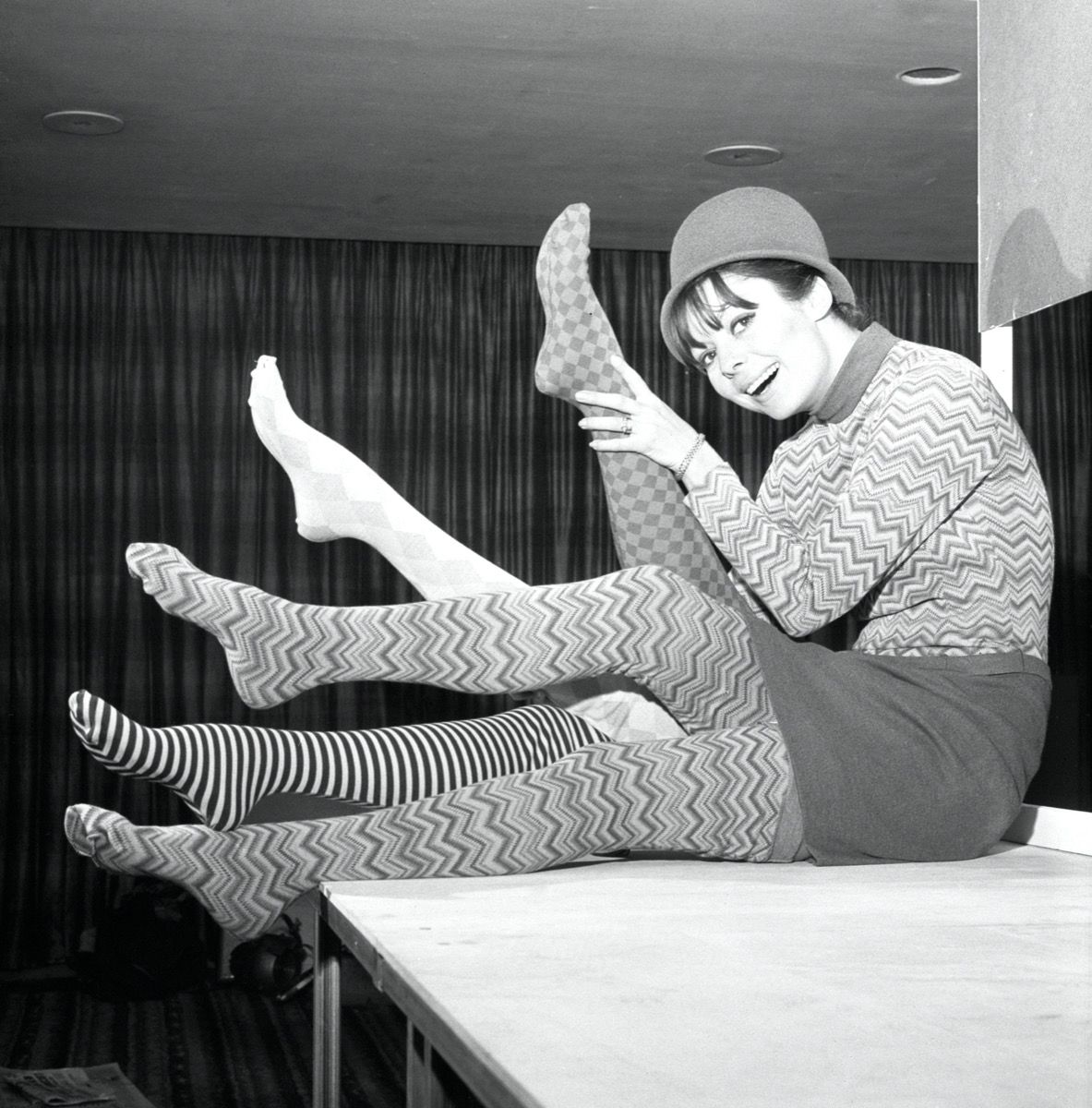 Fotografía en blanco y negro de una mujer en 1960 vistiendo medias estampadas