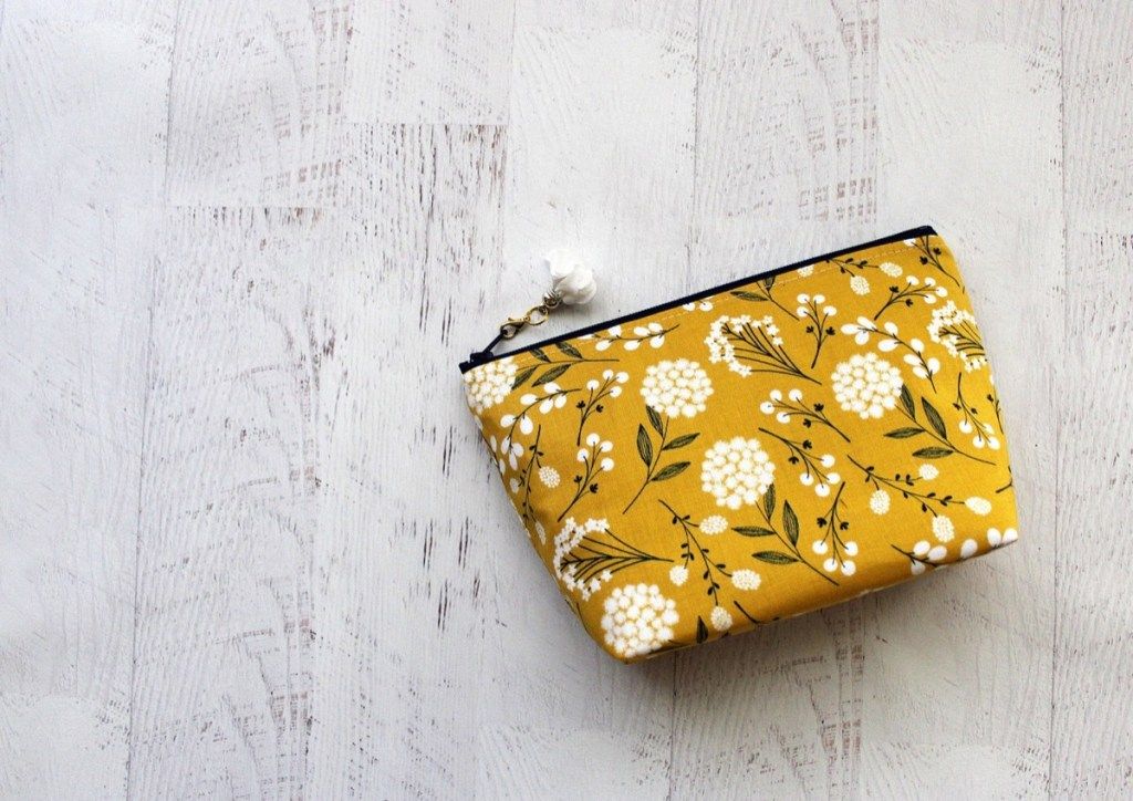 Жълто-бяла флорална чанта на дървен под