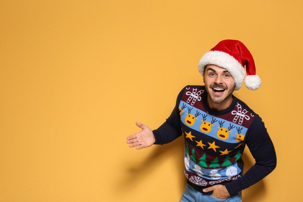 hombre vestido con un gorro de Papá Noel y un suéter navideño