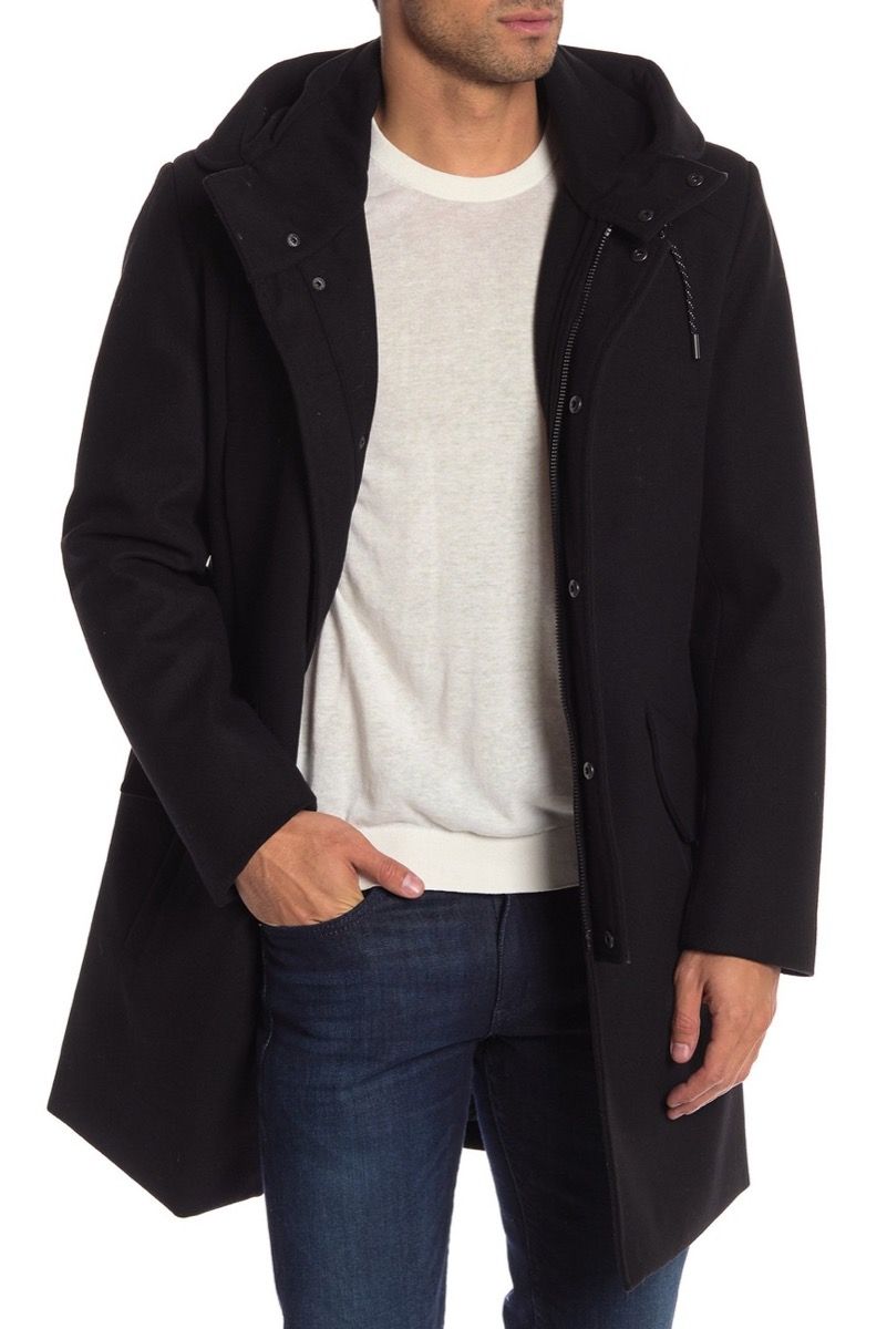 Мъж, облечен в черно палто с качулка