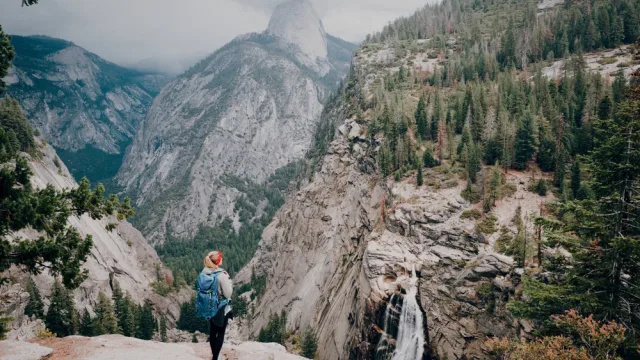   Turista stojaci na vrchole s výhľadom na Yosemitský národný park