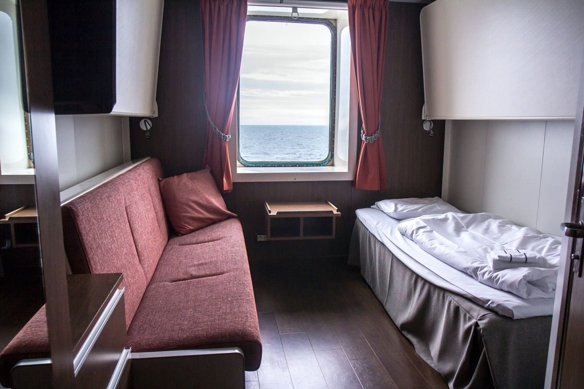 kabin kapal pesiar kecil dengan tempat tidur tunggal dan sofa