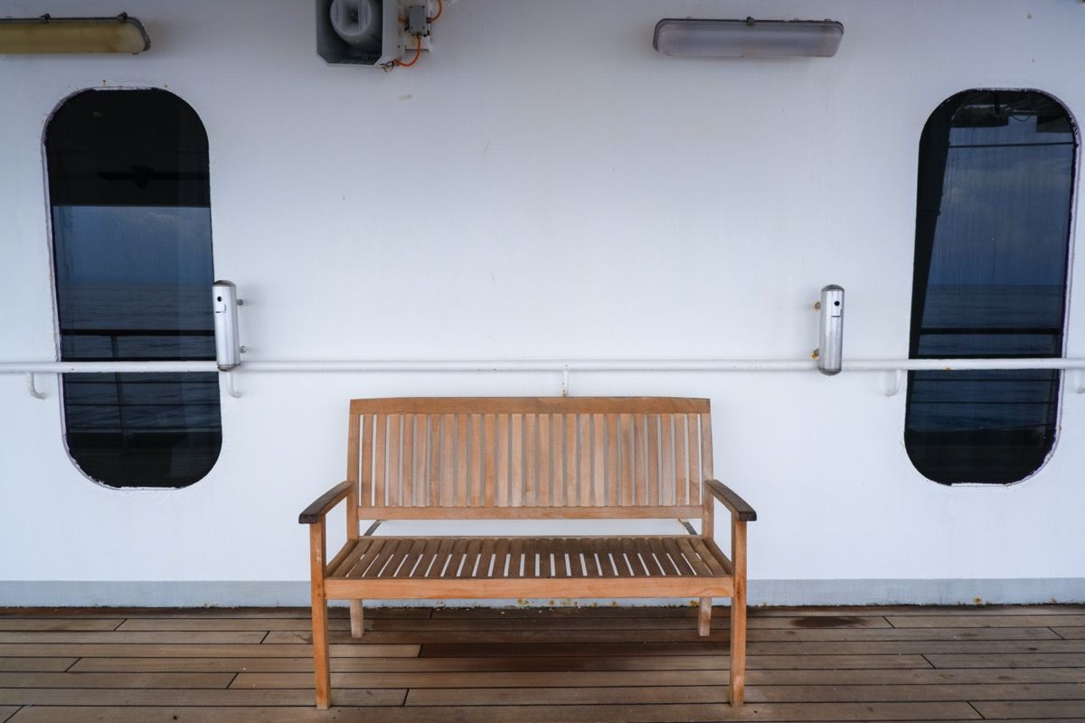 bir gemi yolculuğunda belirlenmiş sigara içme alanının yakınında ahşap tezgah