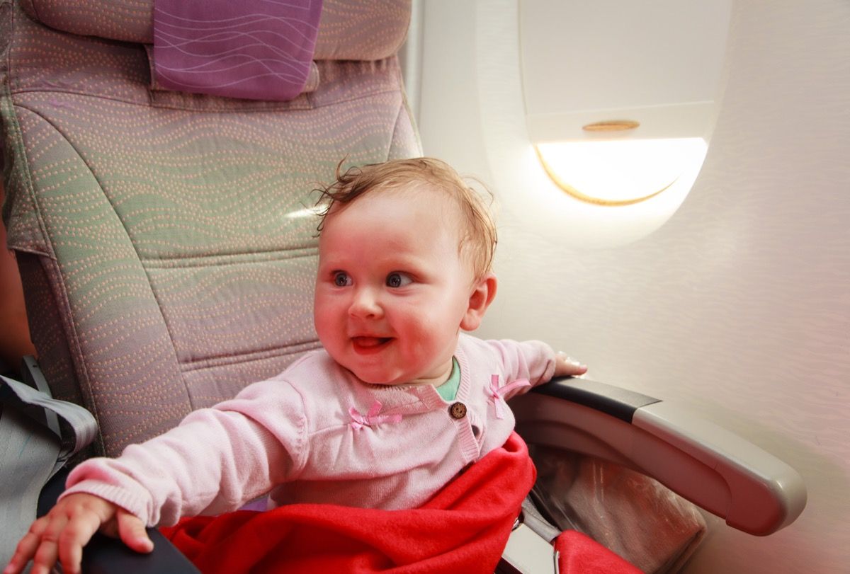 हवाई जहाज पर मुस्कुराता हुआ बच्चा
