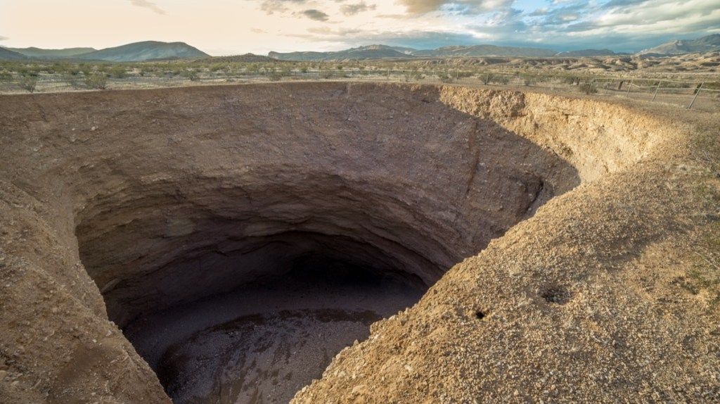 حفرة كهفية رطبة في وادي الموت وسط خلفية صحراوية ، حقيقة تشير إلى نيفادا