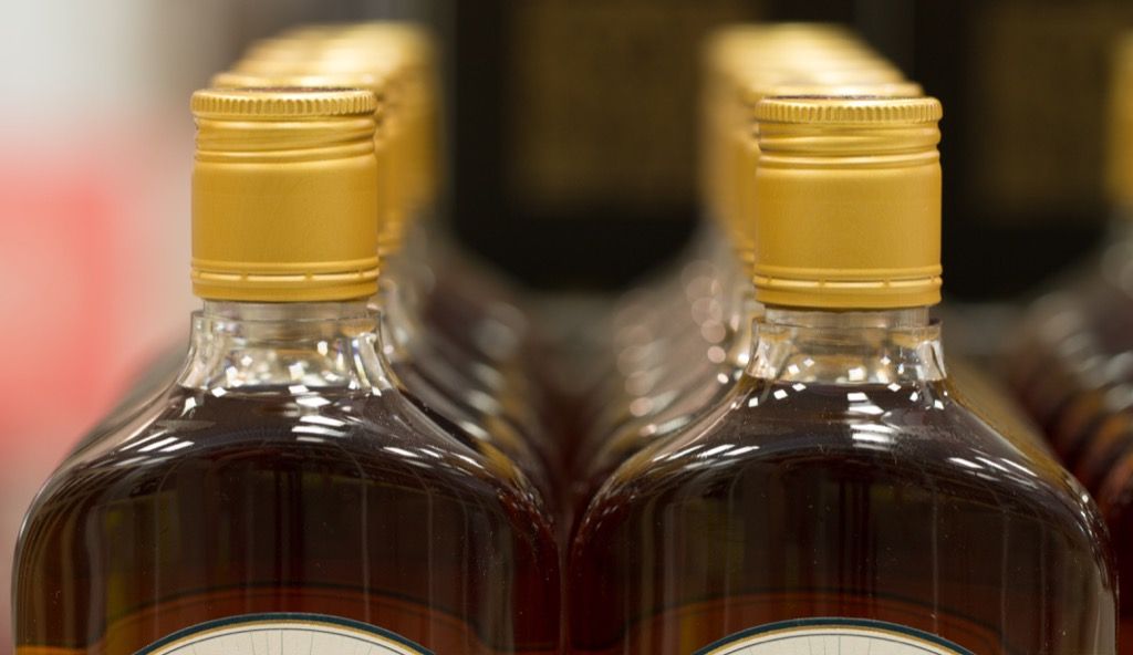 File di bottiglie di rum con coperchi dorati, fatti dichiarati sul Rhode Island