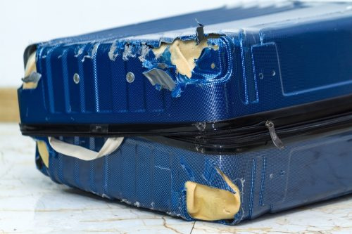   Beschadigde blauwe koffer