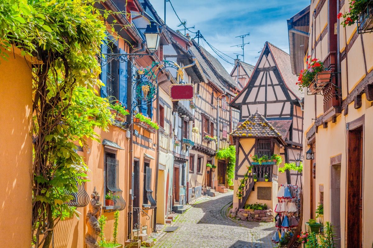võluv tänavapilt värviliste majadega ajaloolises Eguisheimi linnas ilusal päikeselisel päeval suvel sinise taeva ja pilvedega, Alsace, Prantsusmaa