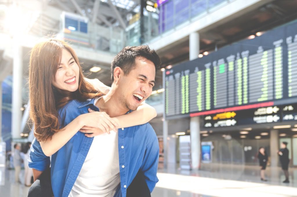 pareja feliz en el aeropuerto reserva vuelos baratos