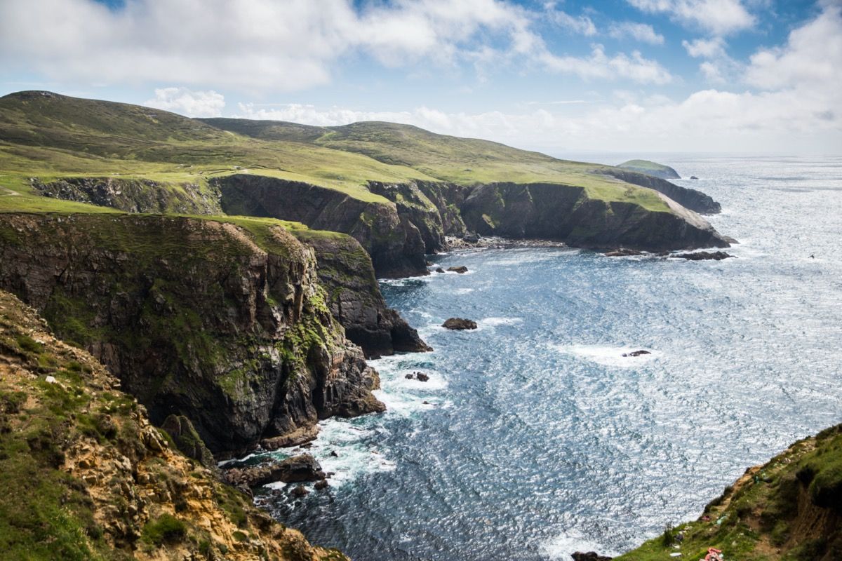 Perto do farol na Ilha Arranmore, os penhascos de 150 pés dominam o horizonte com pássaros marinhos e ondas ondulantes.