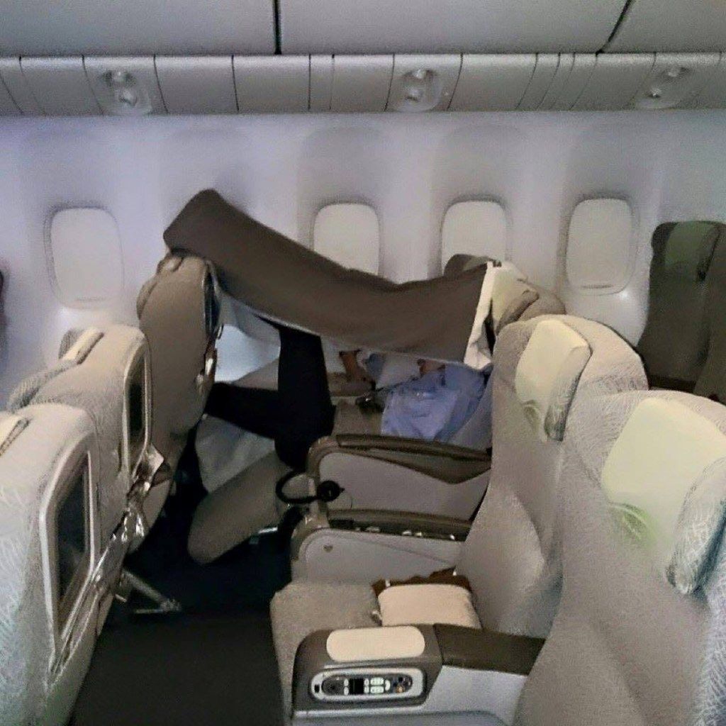 Penumpang pesawat dengan selimut di atas foto kepala penumpang pesawat yang mengerikan