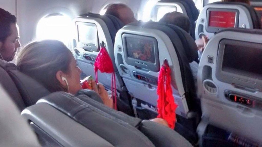 Frau, die Bikini auf Flugzeugfotos von schrecklichen Flugzeugpassagieren austrocknet