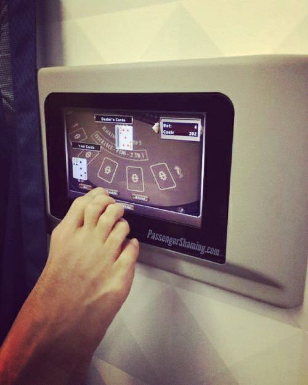 Vīrietis spēlē spēli ar kāju uz briesmīgu lidmašīnas pasažieru fotogrāfijām