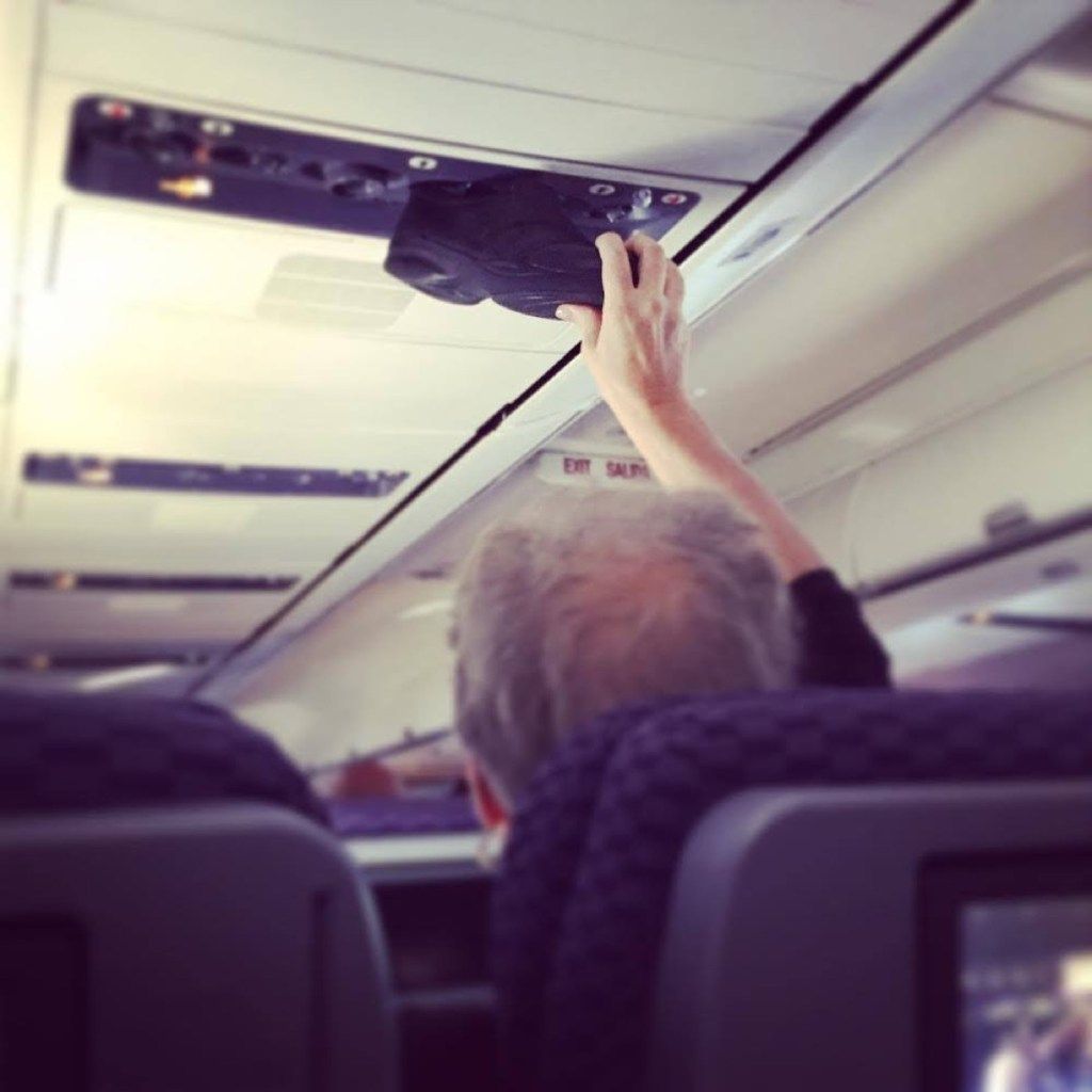 Čovjek stavlja cipele kako bi otvorio fotografije strašnih putnika u avionu