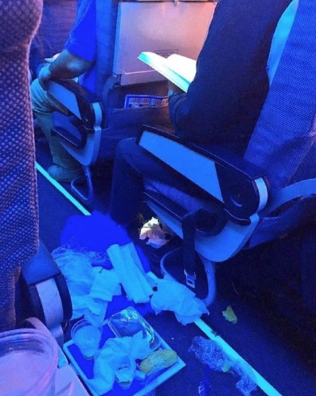 Cilvēks izgāž ēdienu lidmašīnas briesmīgu lidmašīnu pasažieru fotogrāfijās