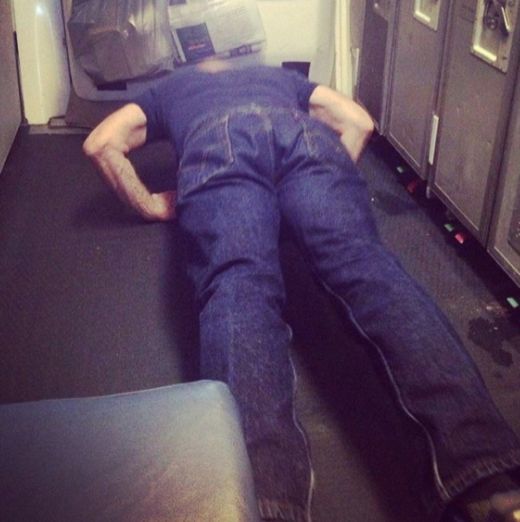 남자는 끔찍한 비행기 승객의 비행 사진 중에 팔 굽혀 펴기를합니다.
