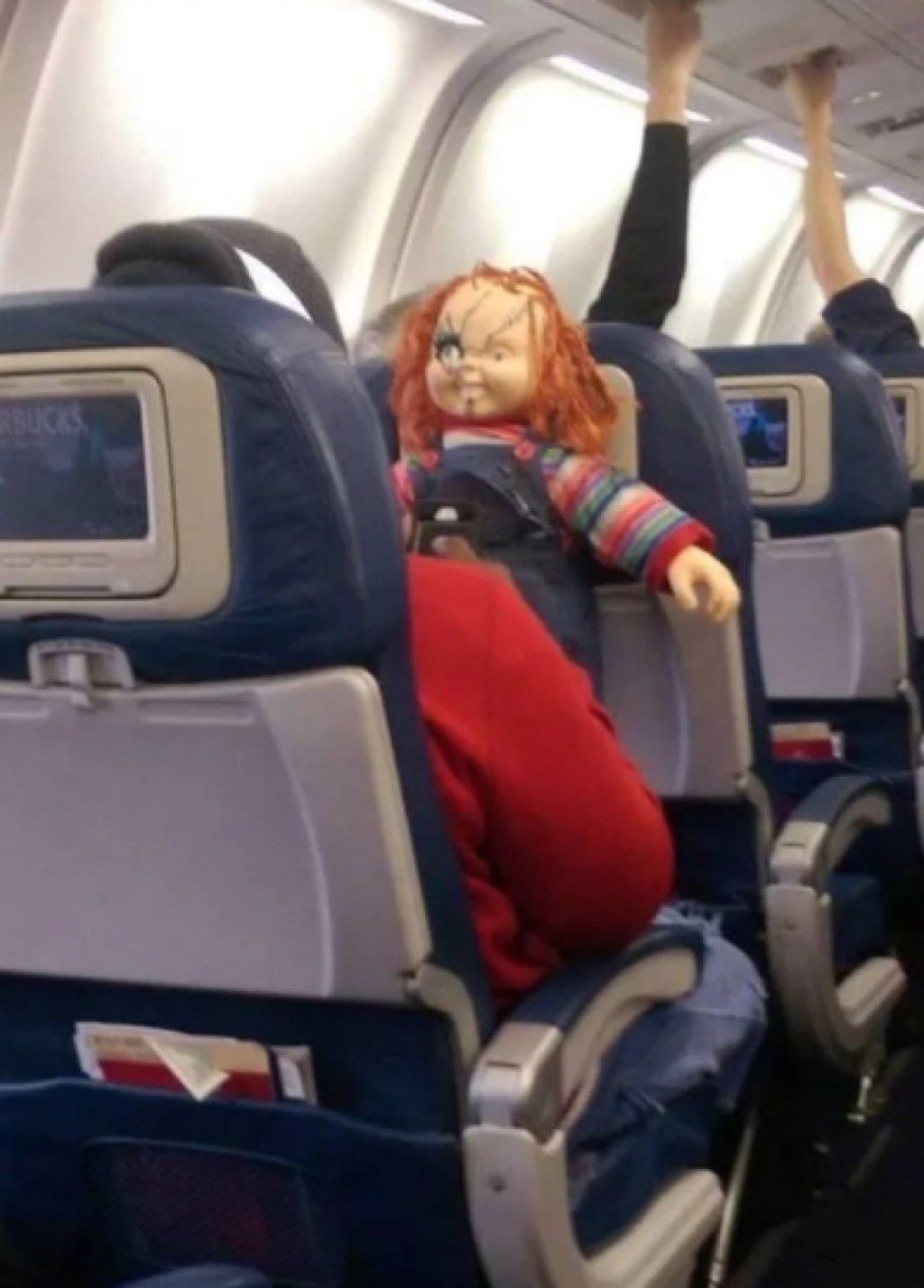 pasažier s fotkami strašidelných bábik strašných cestujúcich v lietadle