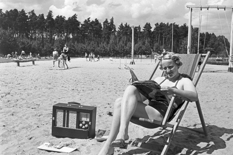 Eine Frau liest ein Buch am Strand