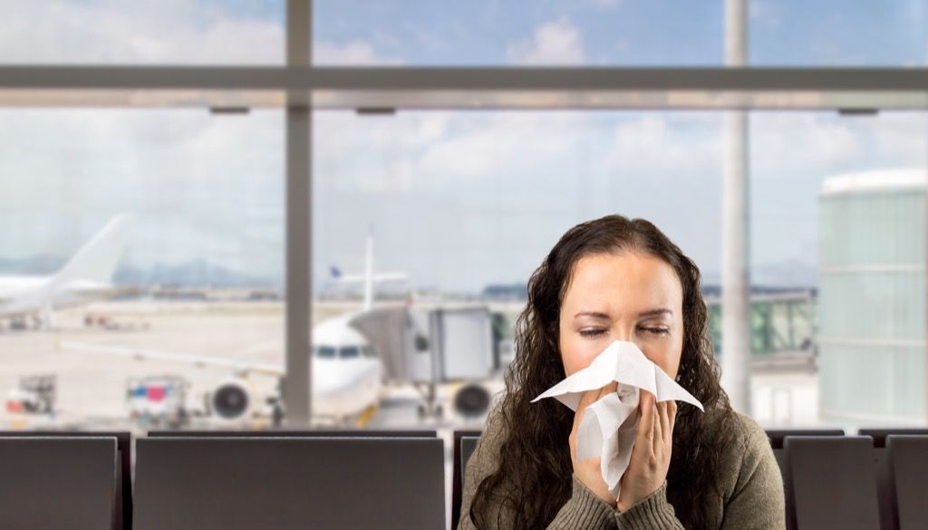 Vrouw niezen op de luchthaven.