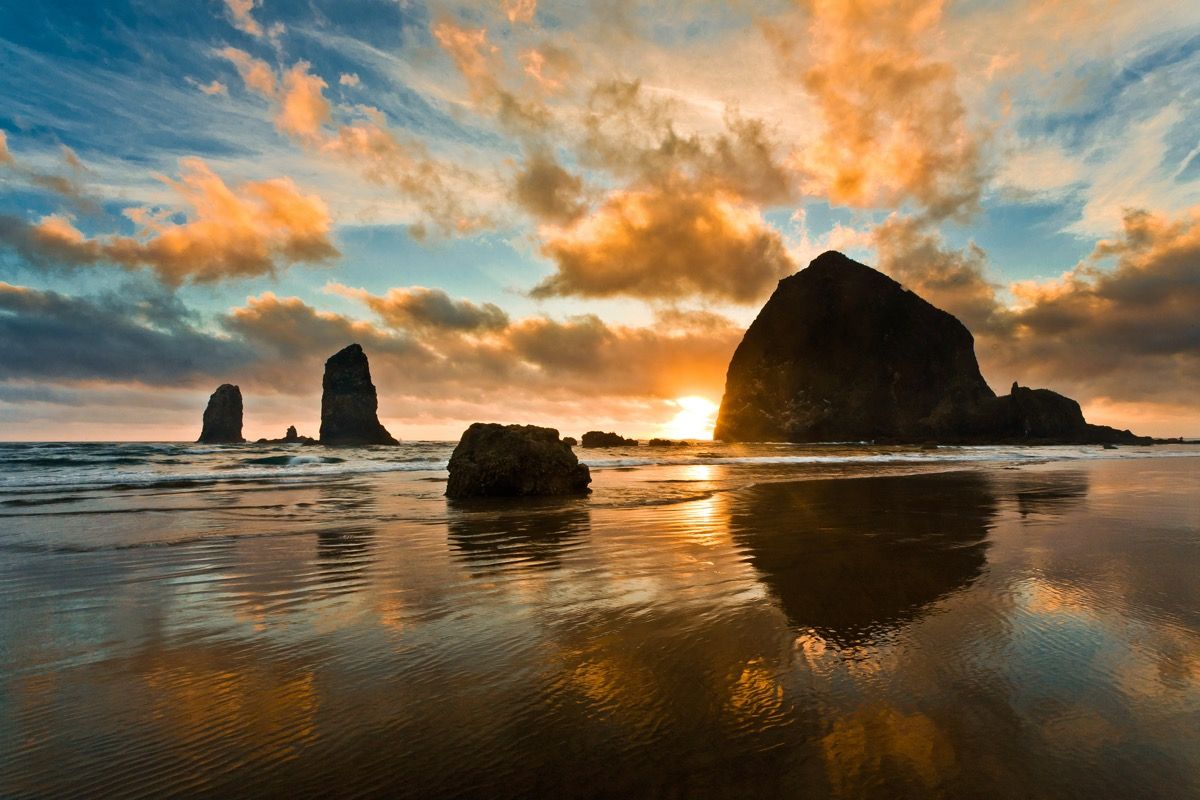 solnedgang over steinblokker på en strand