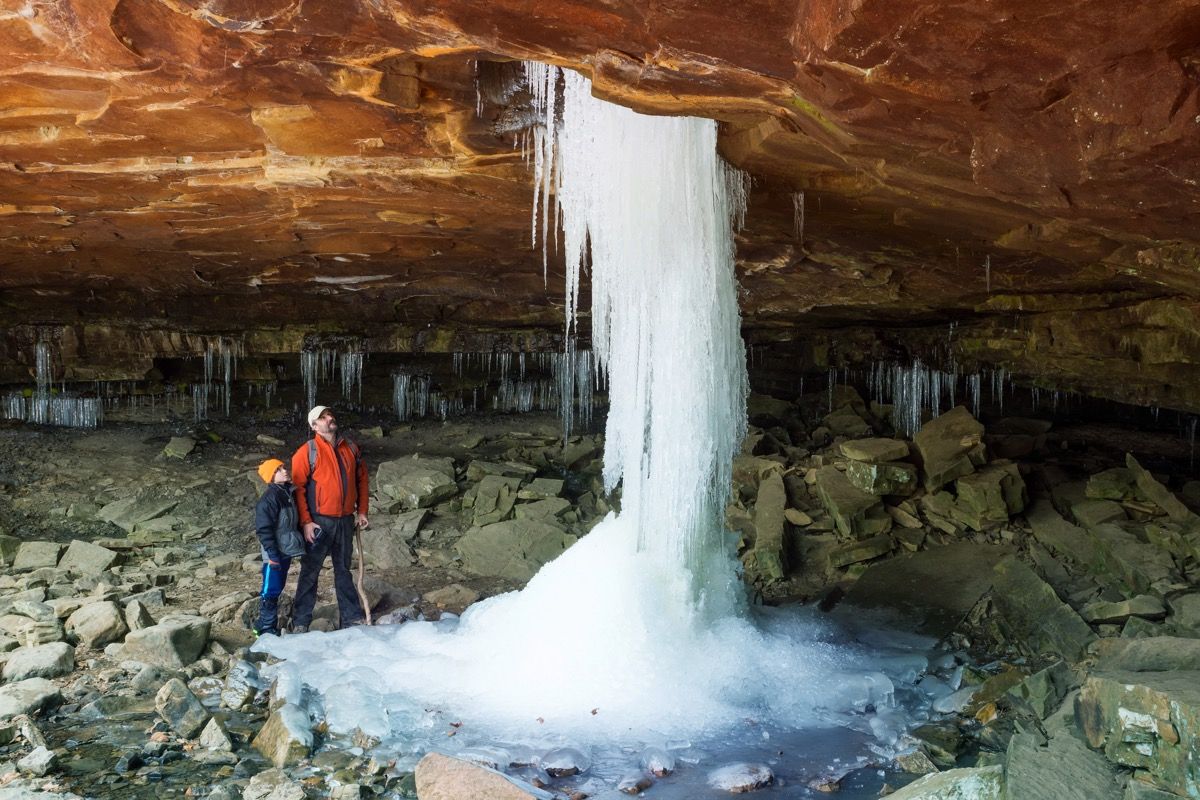 cascada congelada viene a través de un agujero en la roca