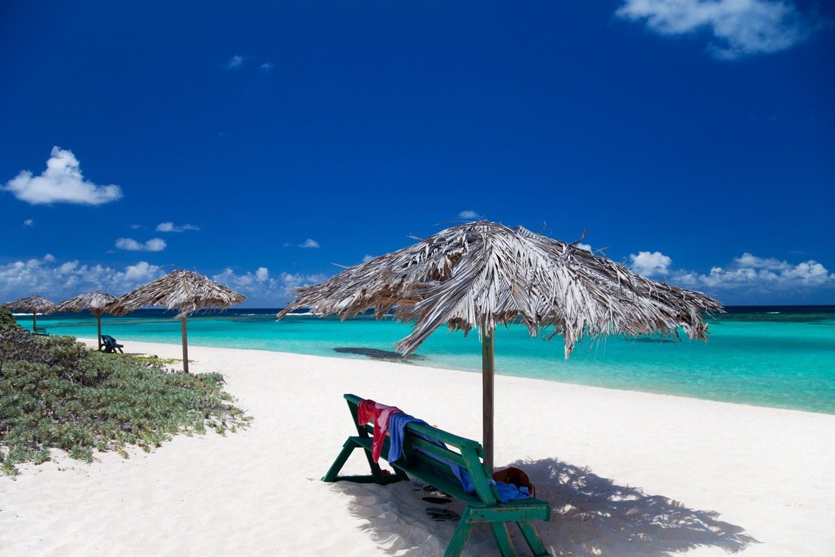пейки под чадъри на кабана на плаж с бял пясък в Анегада, Британски Вирджински острови