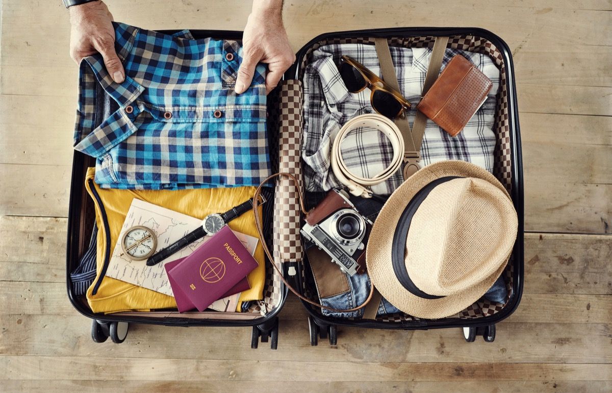 мъж, който опакова куфара си за пътуване