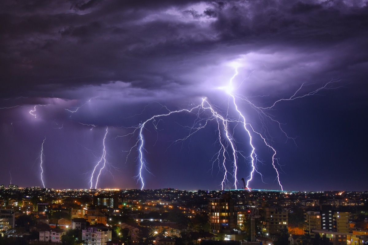 Nevihta strele ponoči sredi vijoličnega neba v mestu Brisbane