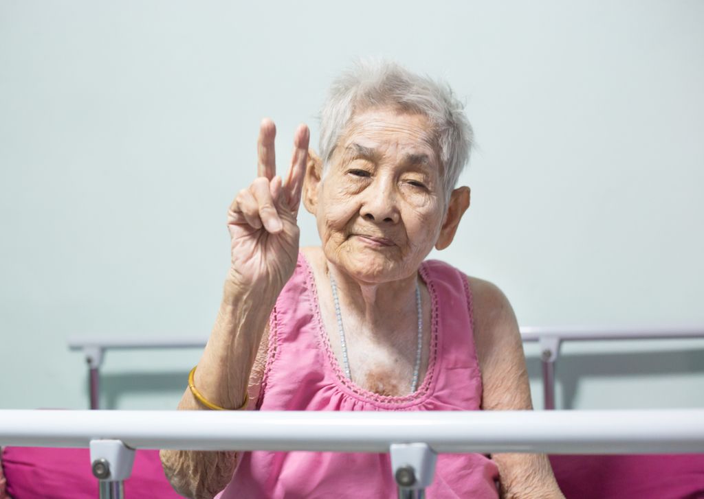 Ältere Frau, die Friedenszeichen hält Yo Mama Witze Selbstmordwald