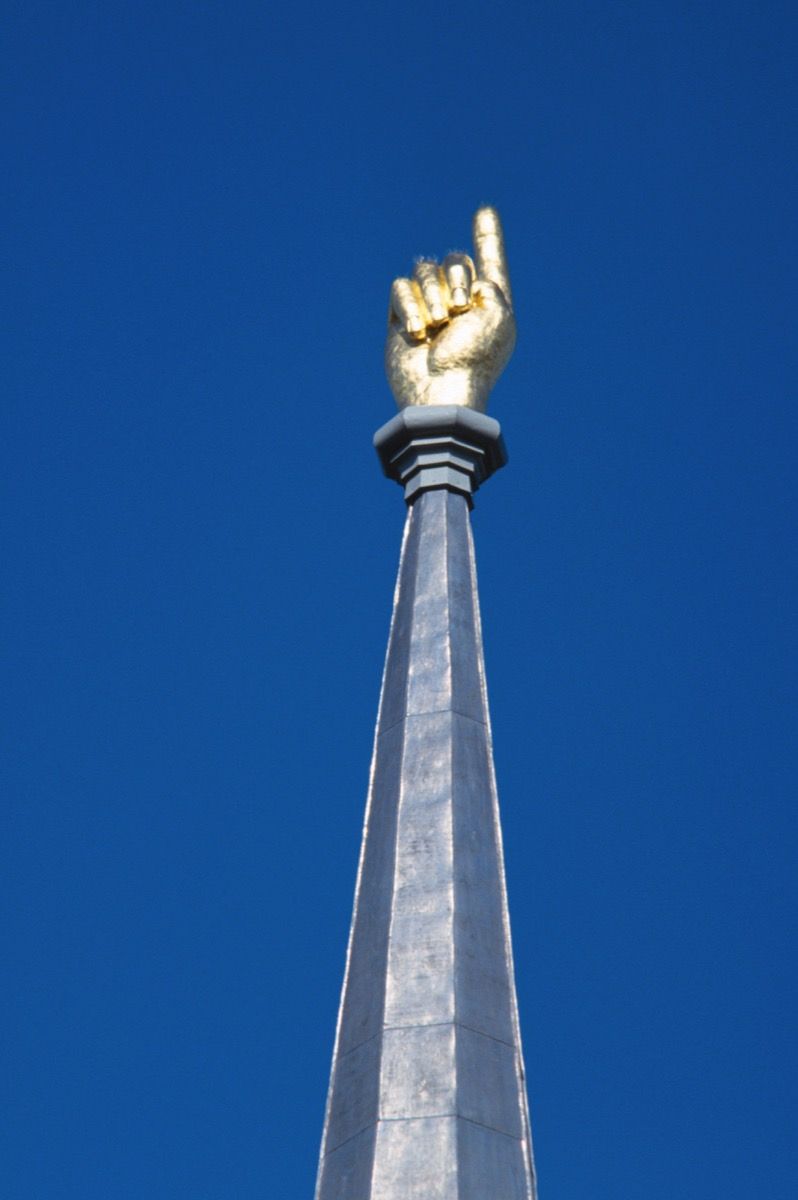 kultainen käsi osoittaa kohti taivasta, outoja valtion maamerkkejä
