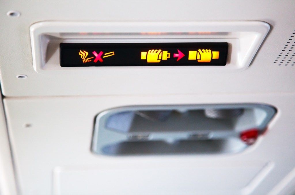 Sicherheitsgurtzeichen an Flugzeugsachen, die Flugbegleiter entsetzen