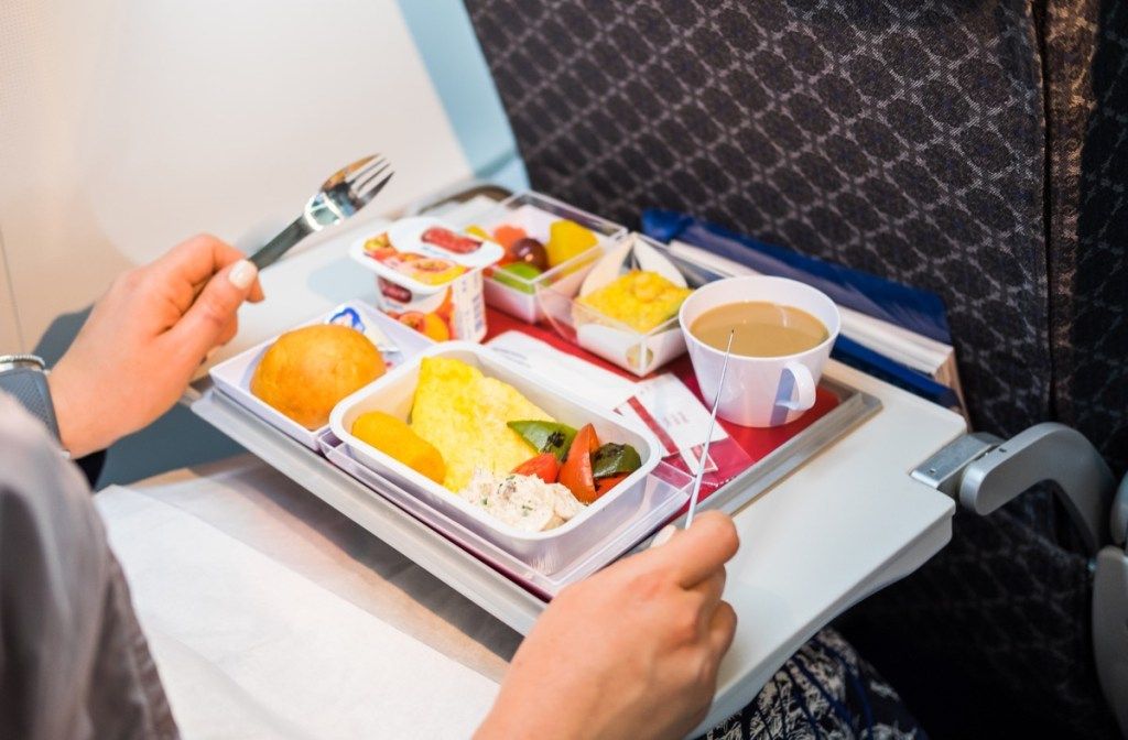 passagier die voedsel eet in het vliegtuig, dingen die stewardessen afschrikken