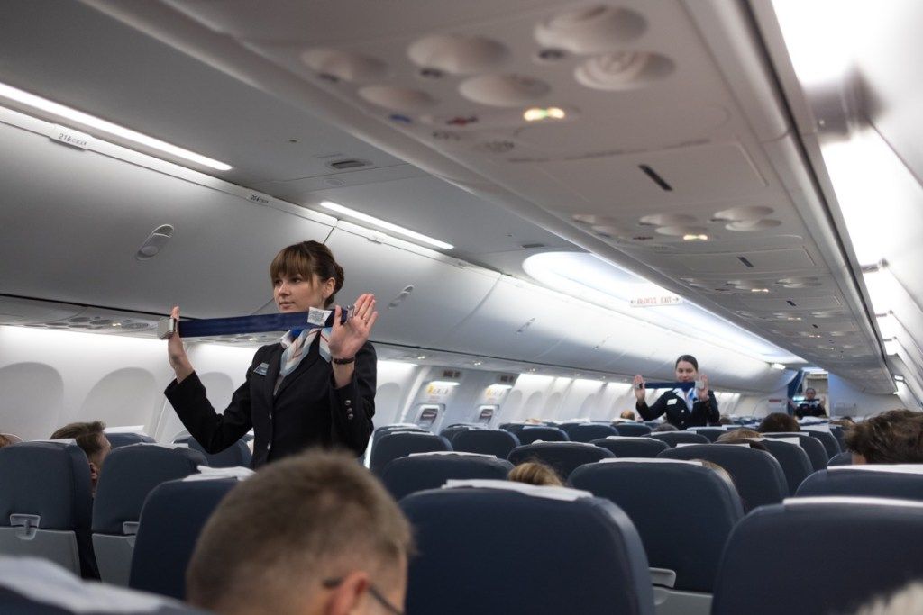 стюардеса, показваща мерки за безопасност на самолета, които ужасяват стюардесите