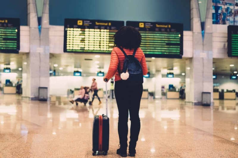   Ung kvinde i lufthavnen tjekker efter flyvningen