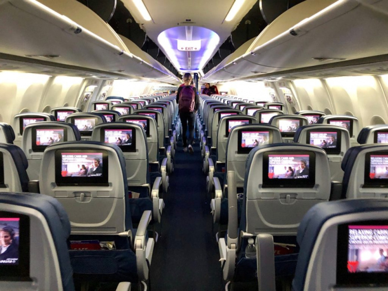   Interior do avião do avião Delta com pessoa desembarcando.