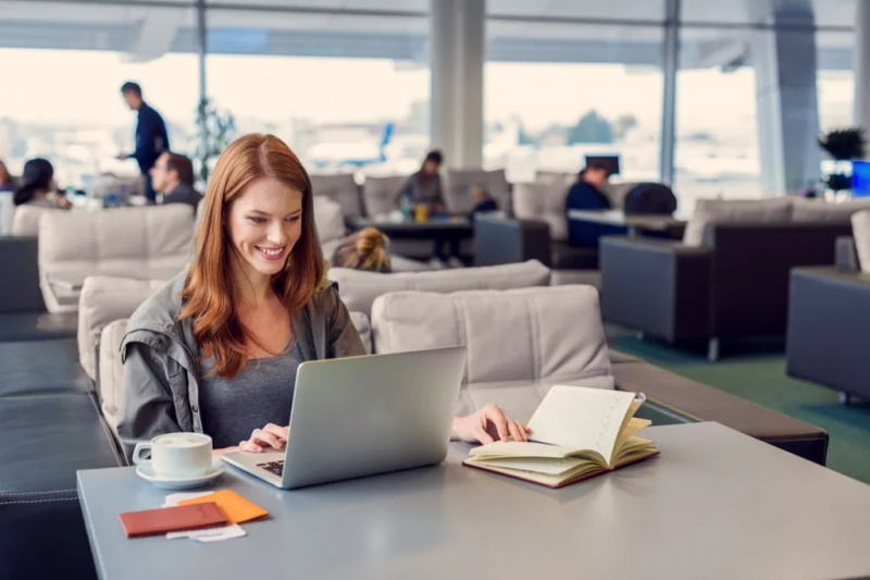   червенокоса жена на лаптоп в салона на летището